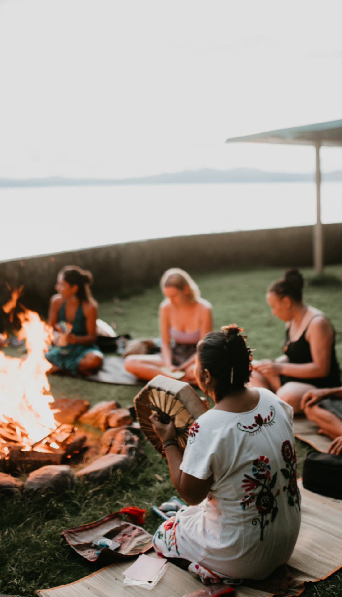 Women gathered around a fire by the Golfo Dulce at dusk in a ceremonial circle